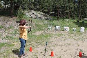 A woman performing archery on the range