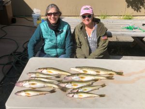 Two women with a catch of fish on the table